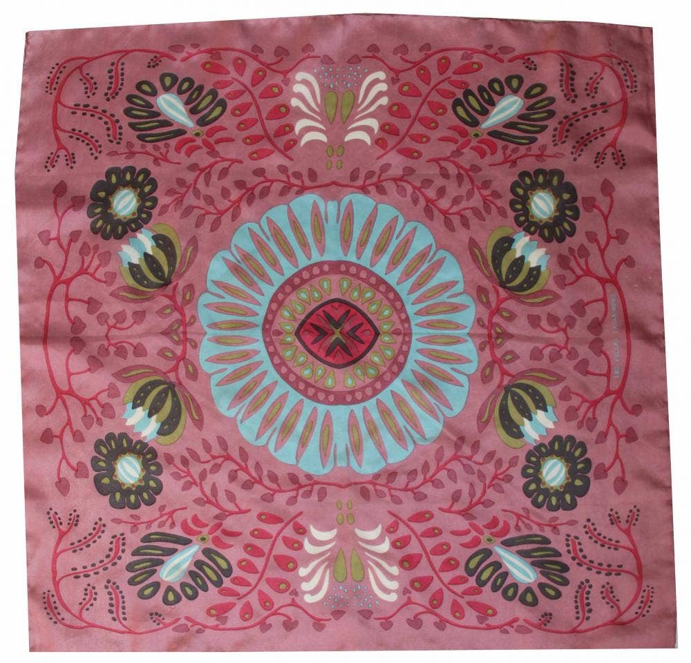 Decorative pink fabric with a central blue floral design and surrounding patterns
