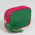 Green and pink pouch with a tassel on a light gray background