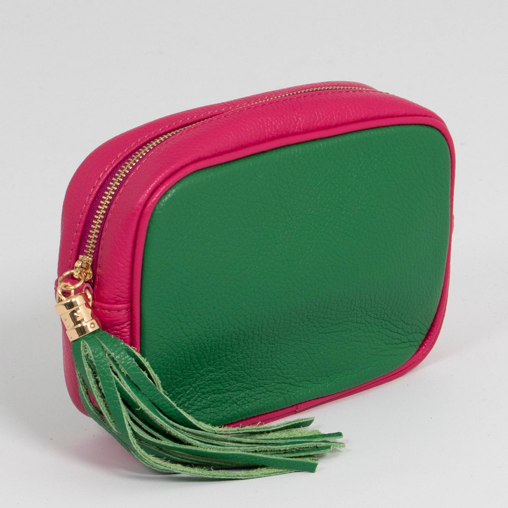 Green and pink pouch with a tassel on a light gray background