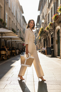 Model holding Vienna Straw and Calf Leather Tote Bag by handles